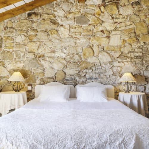 Chambre cosy et romantique avec poutres apparentes et lumière naturelle